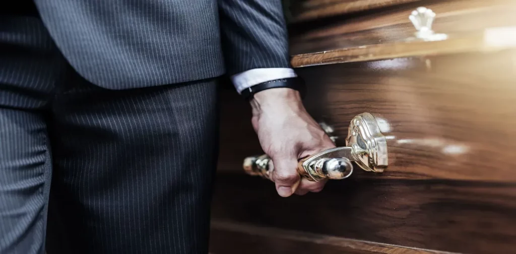 Porteur de cercueil en costume lors d'une cérémonie funéraire en France.